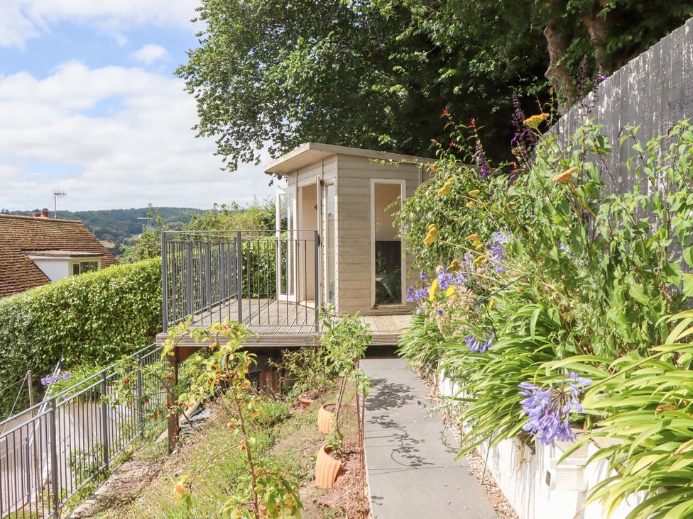 A cabin on a deck surrounded by plants and flowers at 15 Summerland Avenue Dawlish
