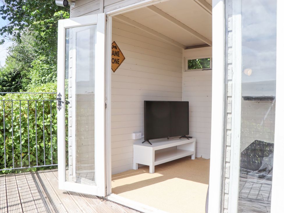 A room with a television and a door leading outside at 15 Summerland Avenue Dawlish