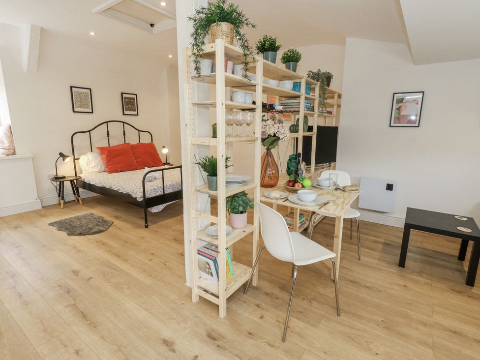 A studio with a bed and dining area at Sea Pink Studio in Swanage