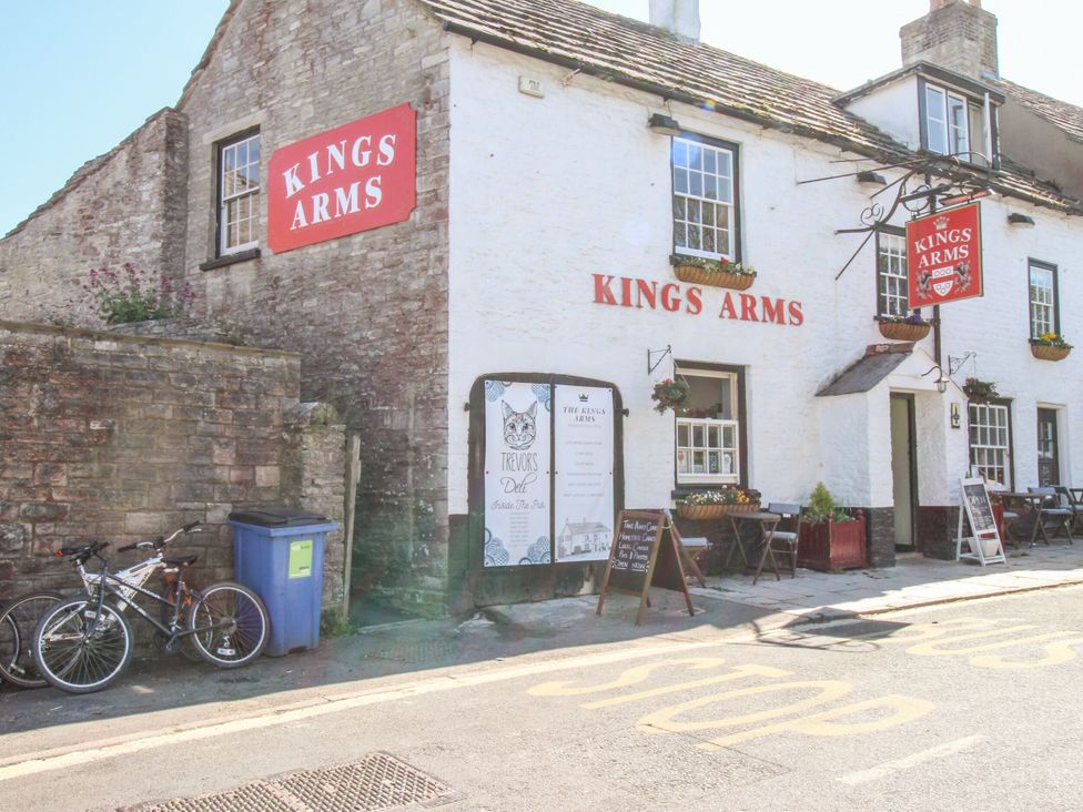An outdoor view of the Kings Arms pub with bicycles and a menu board located at Sea Pink Studio in Swanage