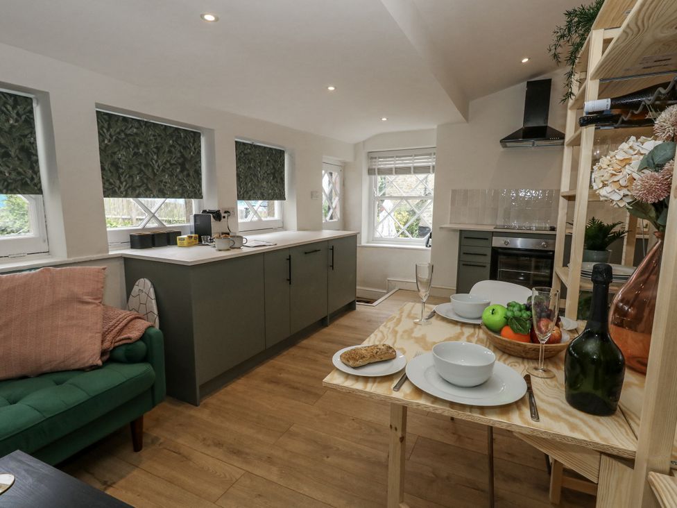 A kitchen with dining table and fruit at Sea Pink Studio in Swanage