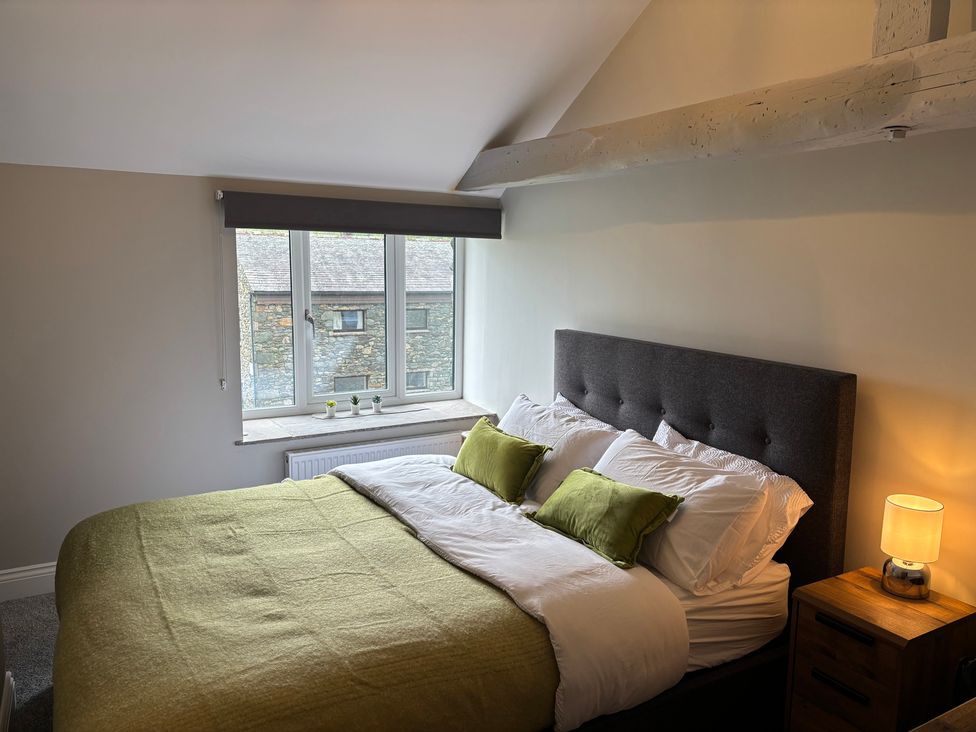 A bedroom with a bed and window at Swirral Edge Cottage in Glenridding
