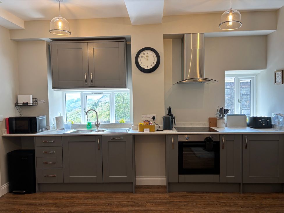 A kitchen with appliances including a microwave and oven at Swirral Edge Cottage in Glenridding