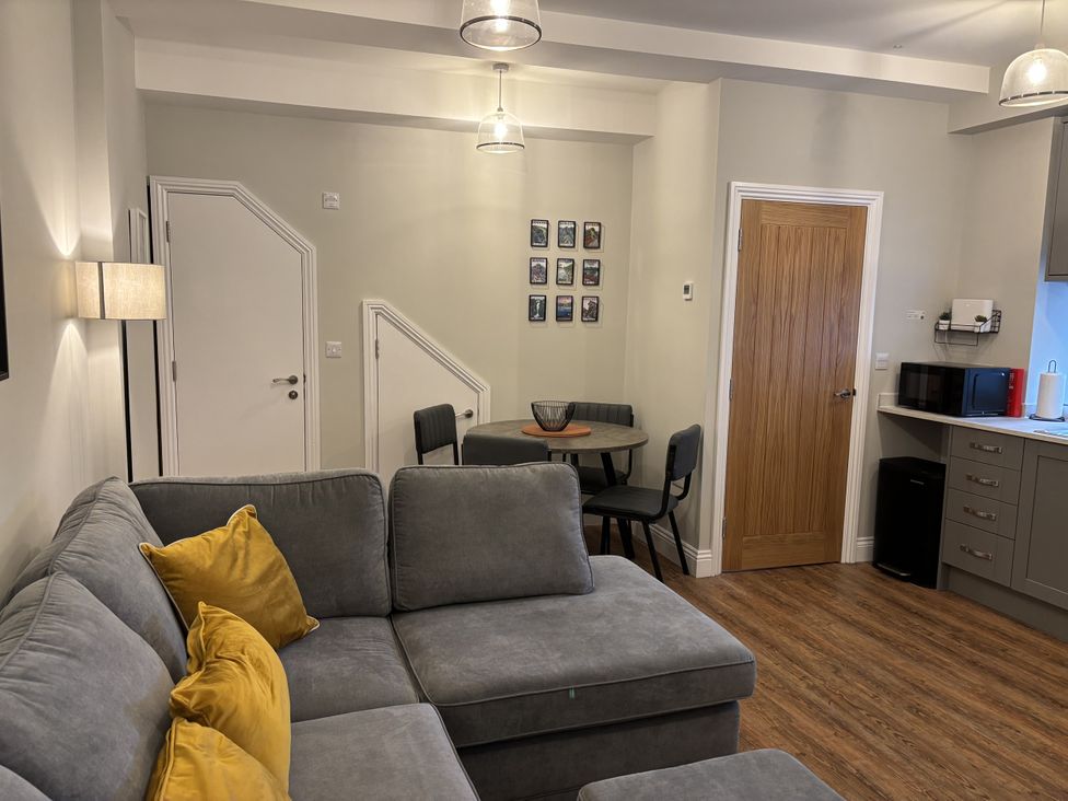 A living room with a sofa and table at Swirral Edge Cottage in Glenridding