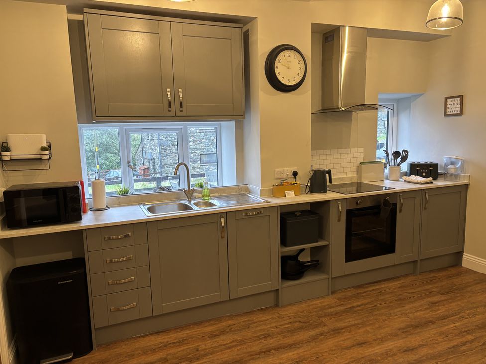 A kitchen with cabinets and appliances at Swirral Edge Cottage in Glenridding