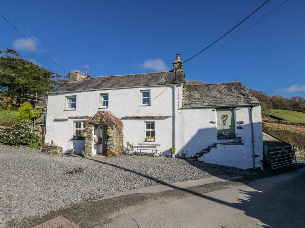 A cottage with a gravel pathway and garden at High Ickenthwaite Farmhouse in Ulverston
