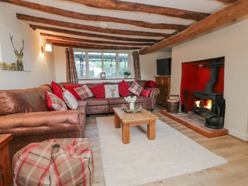 A living room with a sofa and fireplace at High Ickenthwaite Farmhouse in Ulverston