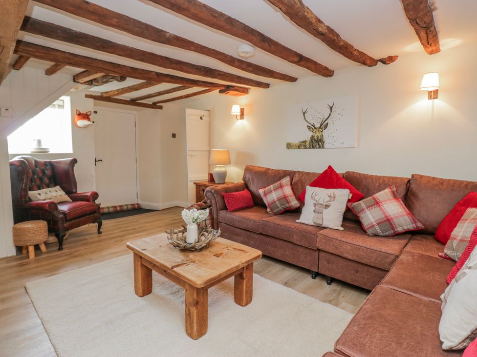 A living room with a sofa and armchair at High Ickenthwaite Farmhouse in Ulverston