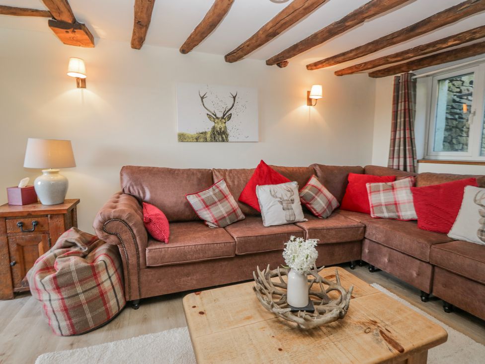 A living room with a sofa and lamp at High Ickenthwaite Farmhouse in Ulverston