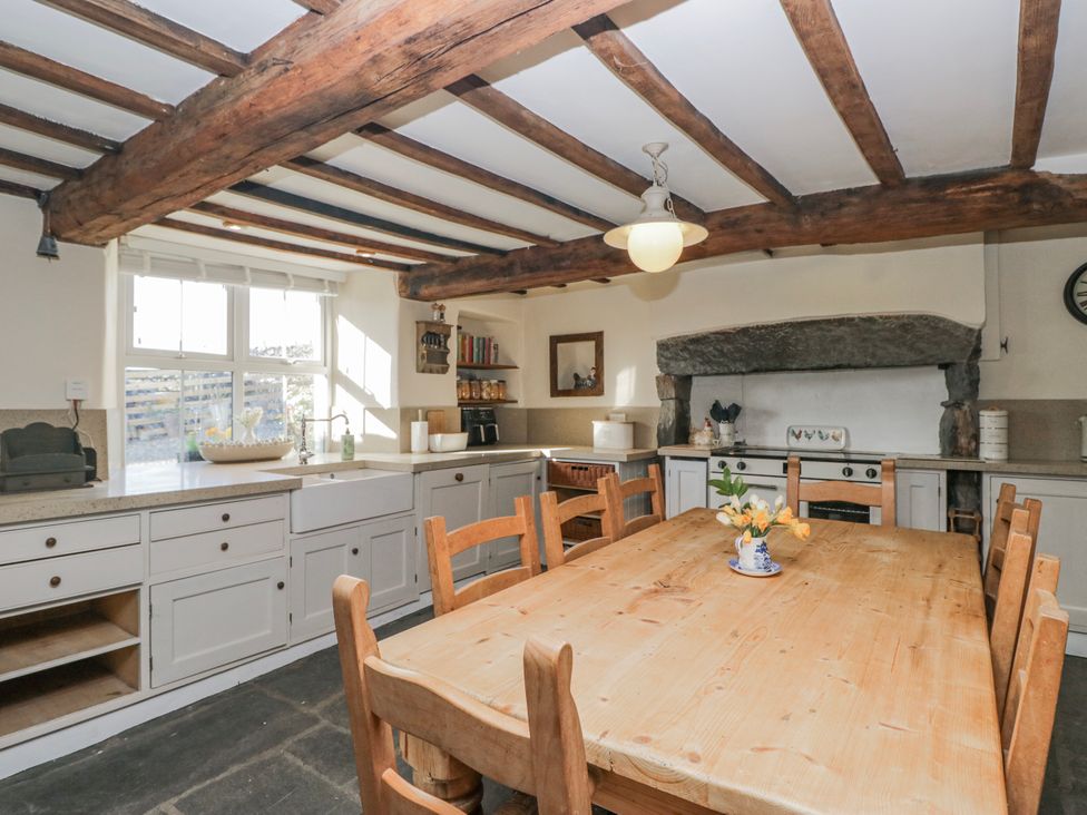 A kitchen with a wooden table and chairs at High Ickenthwaite Farmhouse in Ulverston