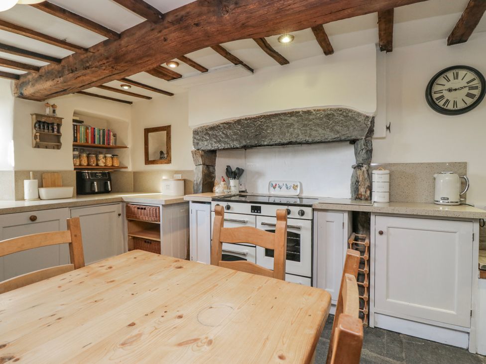 A kitchen with a wooden table and cabinets at High Ickenthwaite Farmhouse in Ulverston