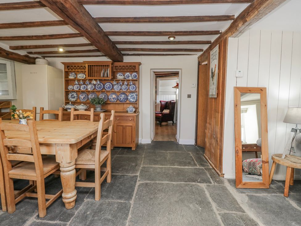 A kitchen with a dining table and refrigerator at High Ickenthwaite Farmhouse in Ulverston