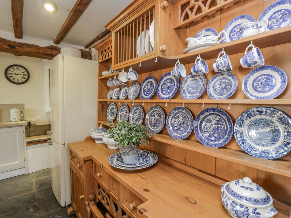 A kitchen with plates and cups on a shelf at High Ickenthwaite Farmhouse in Ulverston