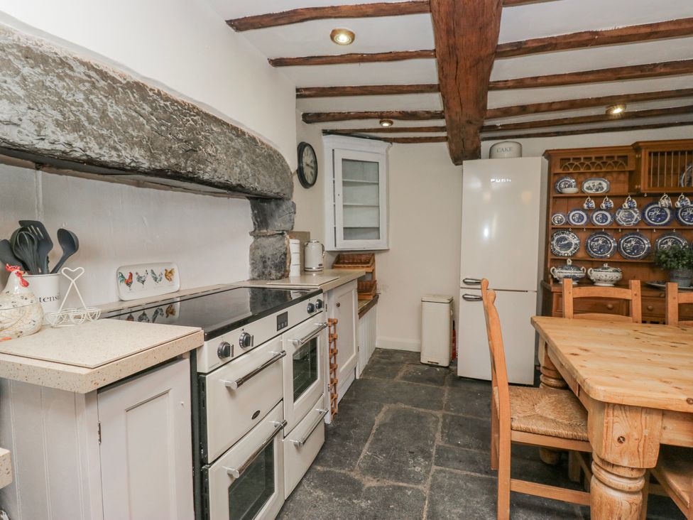 A kitchen with an oven and a table at High Ickenthwaite Farmhouse in Ulverston