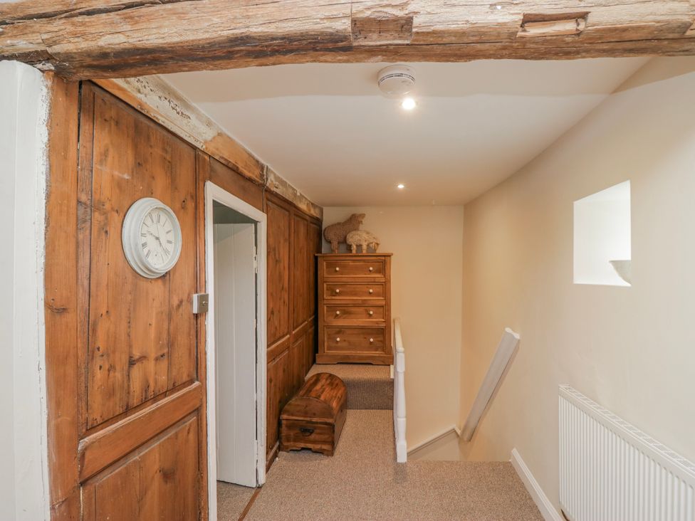 A hallway with a clock and a drawer at High Ickenthwaite Farmhouse in Ulverston