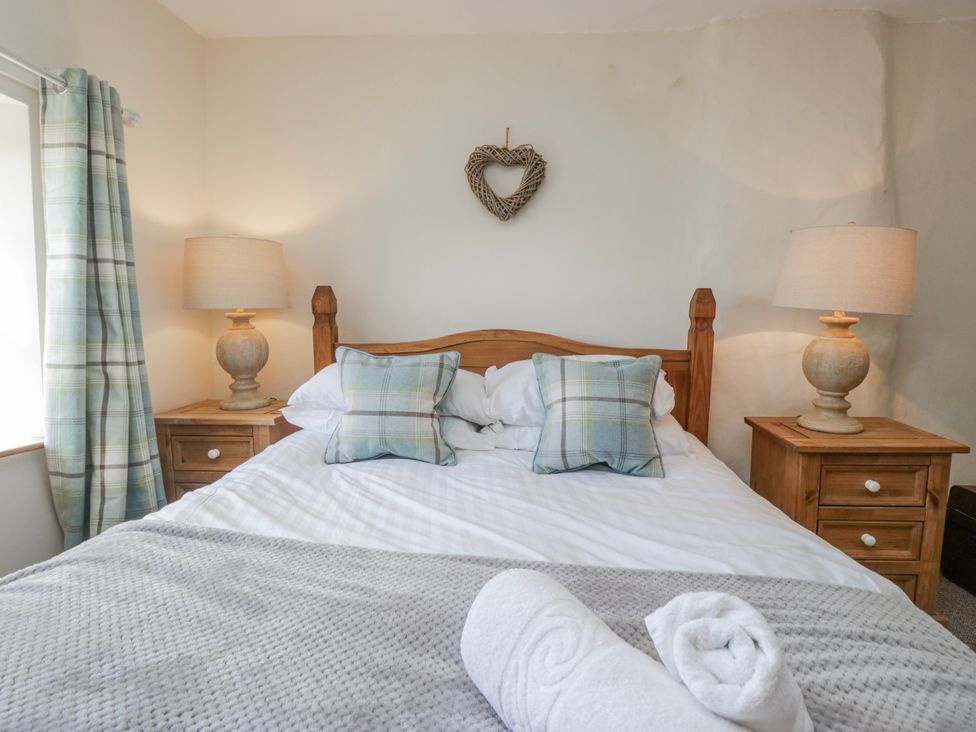 A bedroom with a bed and bedside tables at High Ickenthwaite Farmhouse in Ulverston