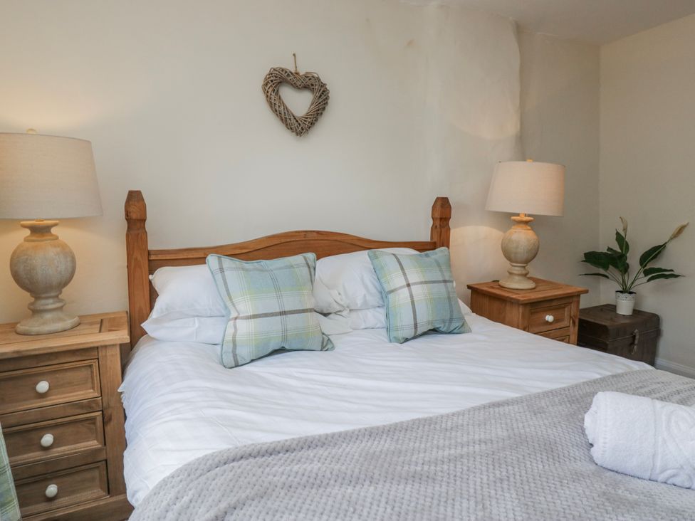A bedroom with a bed and bedside tables at High Ickenthwaite Farmhouse, Ulverston