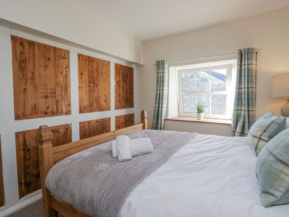 A bedroom with a bed and window at High Ickenthwaite Farmhouse Ulverston