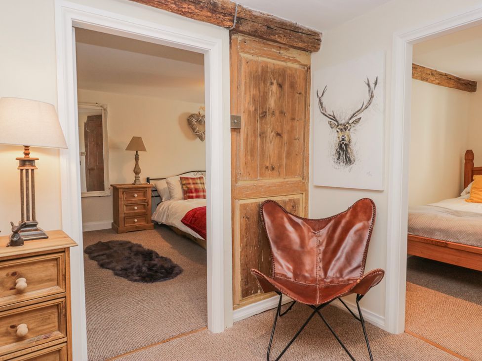 A bedroom with a chair and lamp at High Ickenthwaite Farmhouse in Ulverston