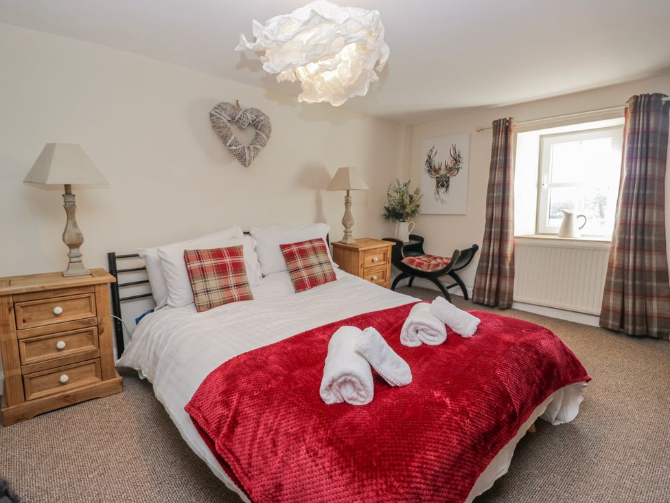 A bedroom with a bed and side tables at High Ickenthwaite Farmhouse in Ulverston
