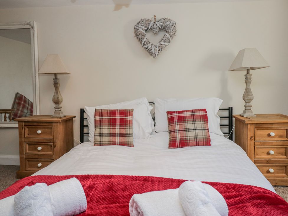 A bedroom with a bed and bedside tables at High Ickenthwaite Farmhouse in Ulverston