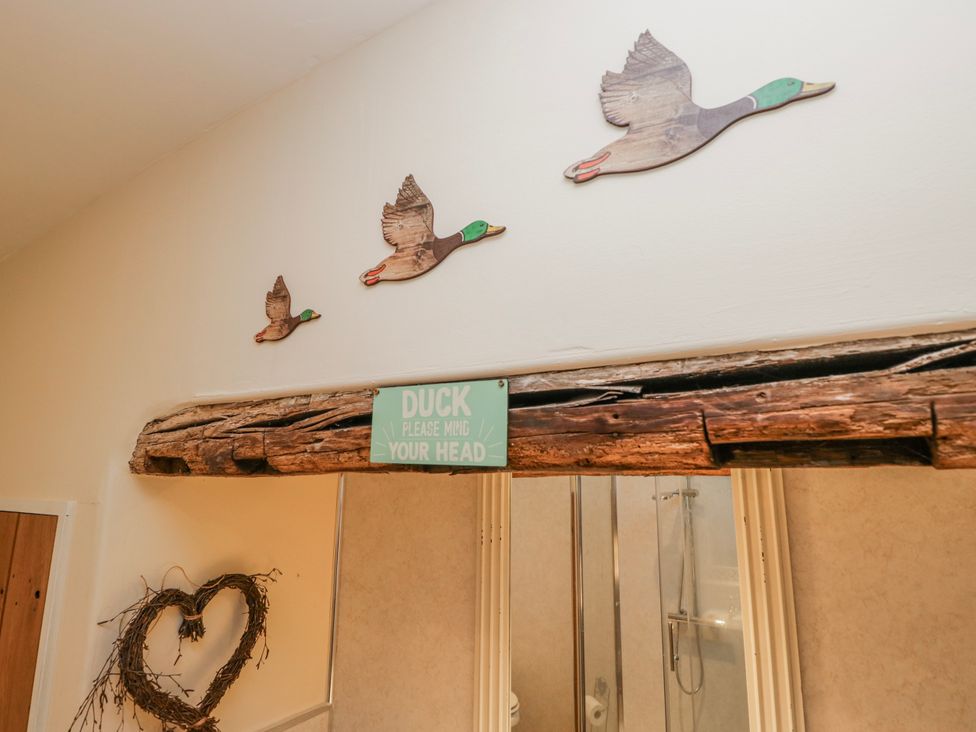 A hallway with wooden ducks on the wall at High Ickenthwaite Farmhouse in Ulverston