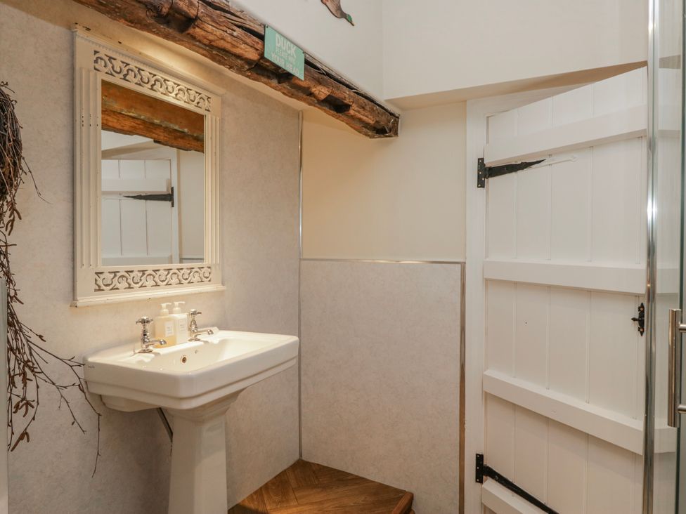 A bathroom with a sink and mirror at High Ickenthwaite Farmhouse in Ulverston