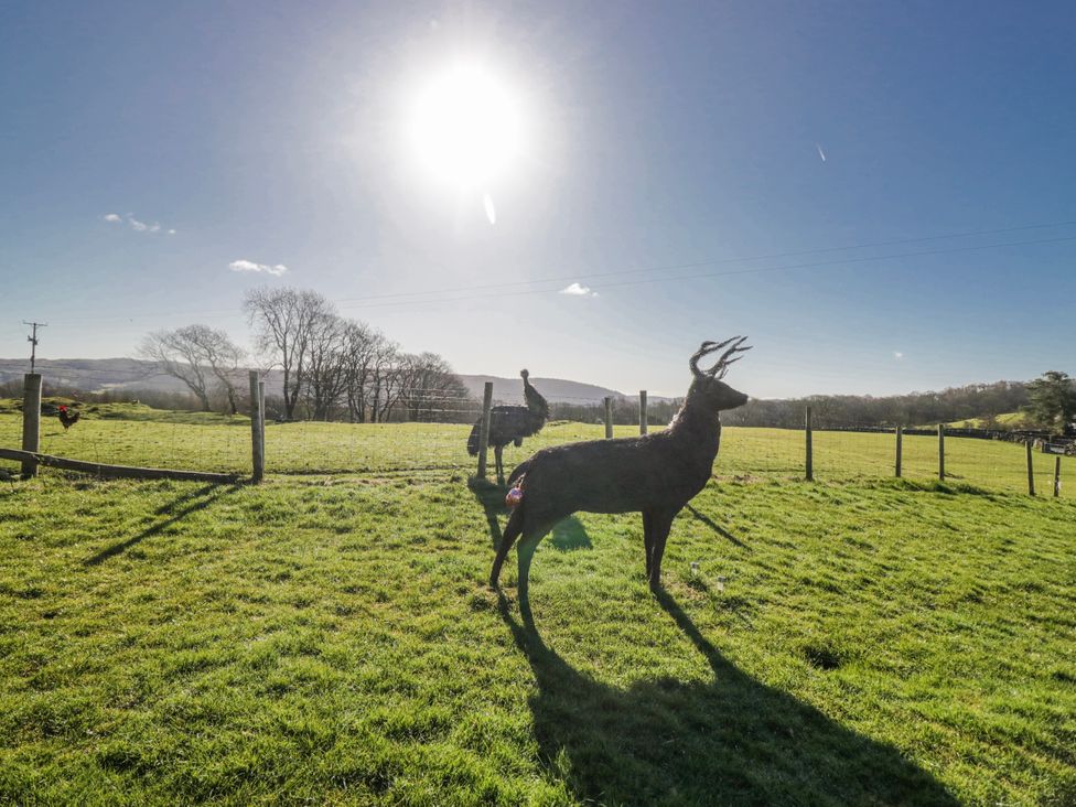 A deer sculpture in a field with a fence at High Ickenthwaite Farmhouse in Ulverston