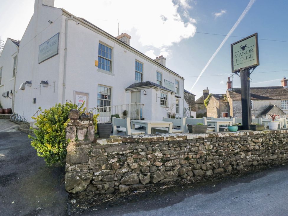 An outdoor view of the Manor House showing tables and chairs at High Ickenthwaite Farmhouse Ulverston