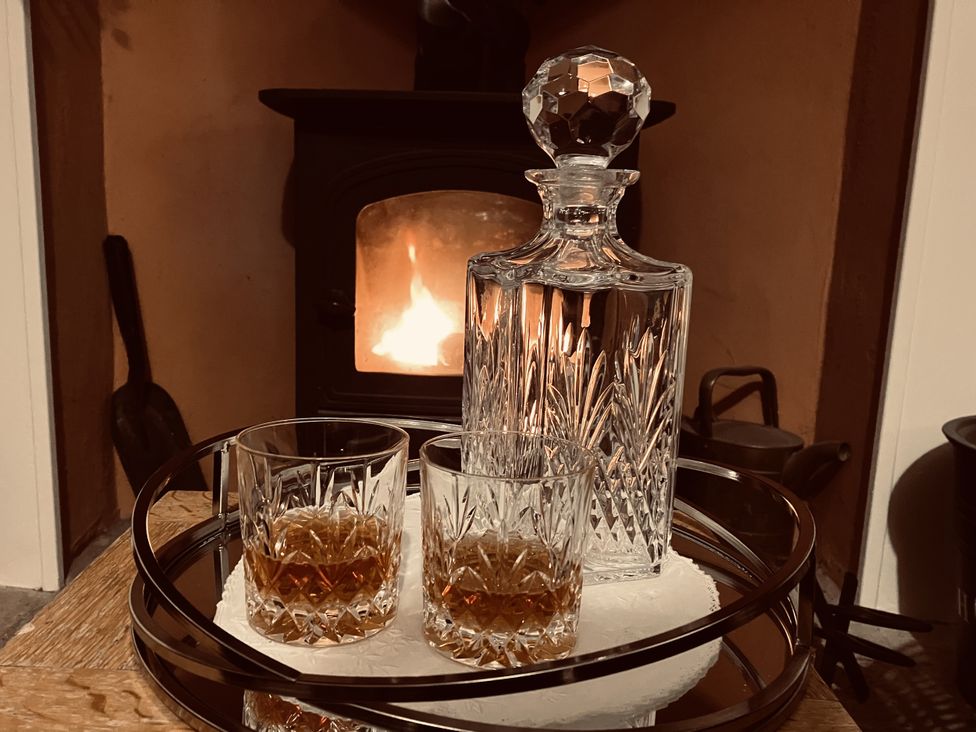 A decanter and glasses on a tray in front of a fireplace at The Steading in Castle Douglas