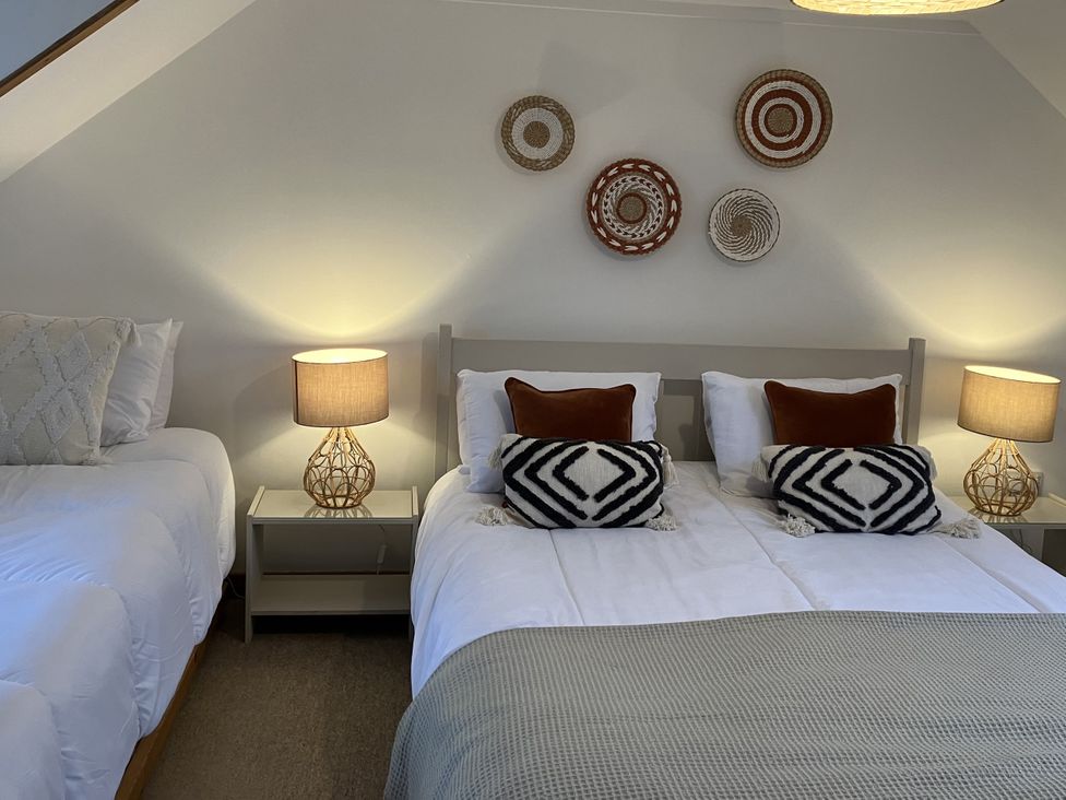 A bedroom with two beds and lamps at The Steading in Castle Douglas