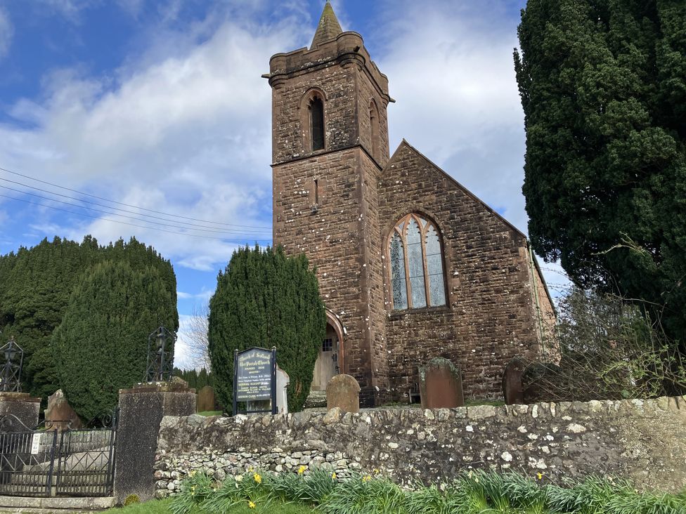 A church with gravestones and trees at The Steading in Castle Douglas