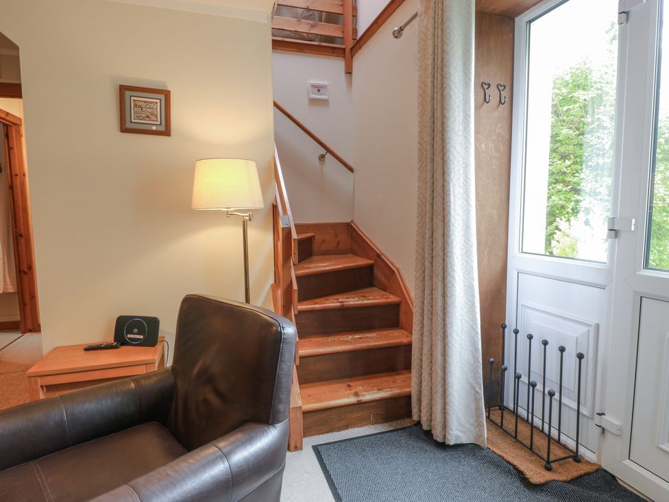 A living room with an armchair and staircase at The Steading in Castle Douglas