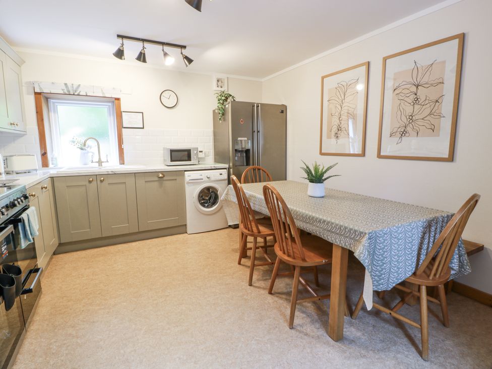 A kitchen with a dining table and appliances at The Steading in Castle Douglas