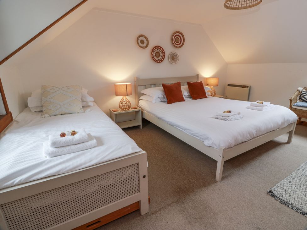 A bedroom with two beds and side tables at The Steading in Castle Douglas
