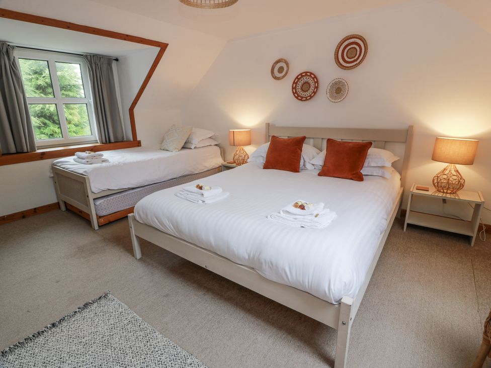 A bedroom with a double bed and single bed at The Steading in Castle Douglas