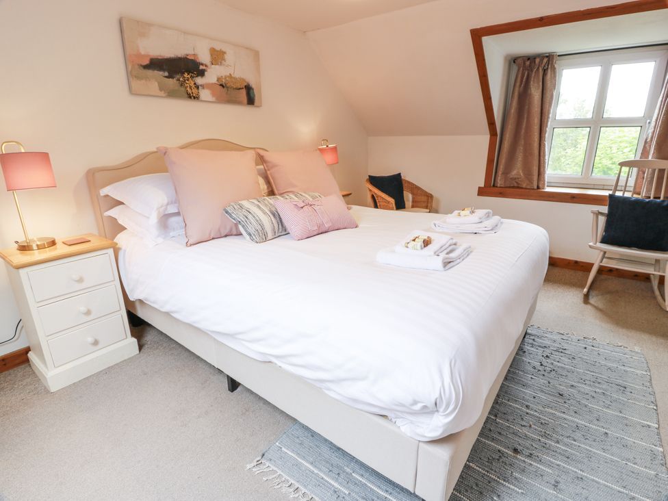 A bedroom with a bed and nightstand at The Steading in Castle Douglas