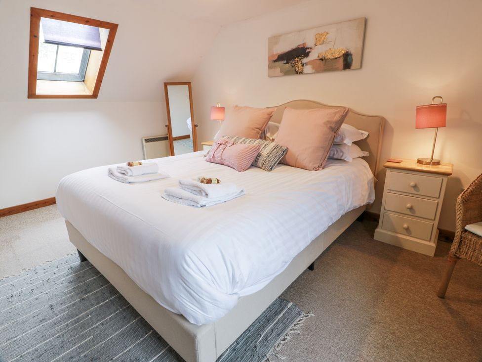 A bedroom with a double bed and bedside table at The Steading in Castle Douglas