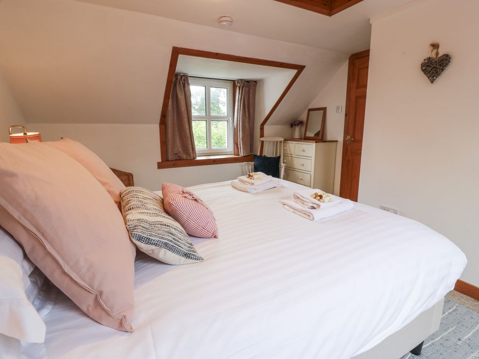 A bedroom with a bed and window at The Steading in Castle Douglas