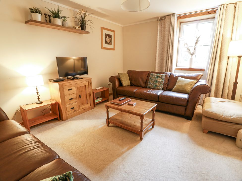 A living room with a sofa and television at The Steading in Castle Douglas