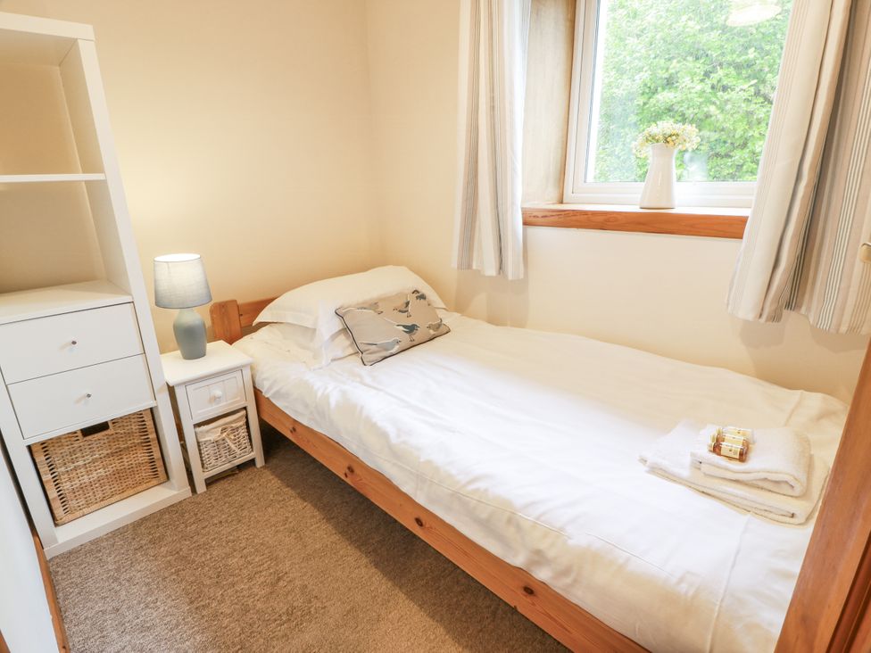 A bedroom with a single bed and bookshelf at The Steading in Castle Douglas