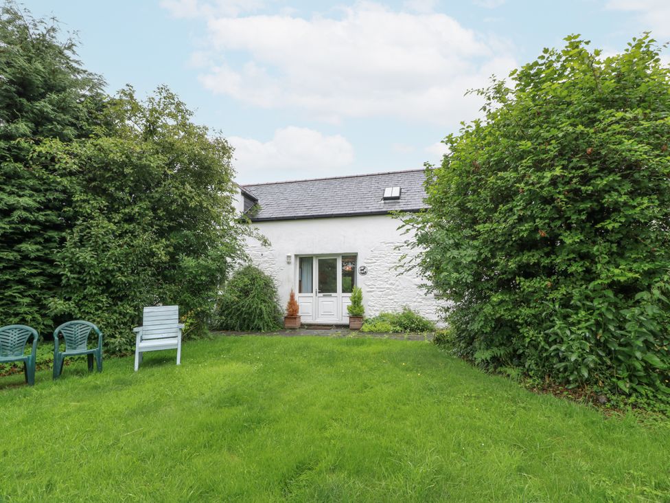 A house with a garden and chairs at The Steading in Castle Douglas