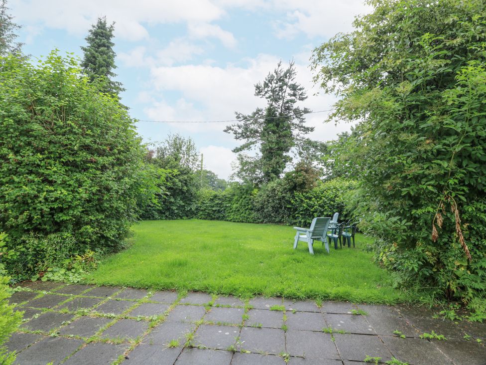 A garden with green grass and chairs at The Steading in Castle Douglas