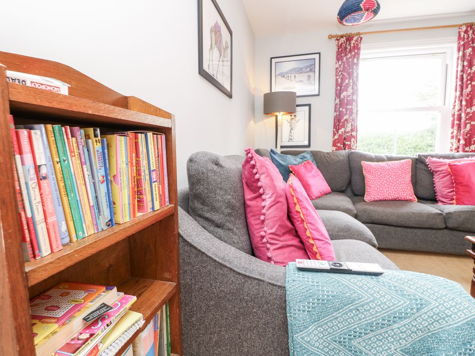 A living room with a bookshelf and sofa at Milston in Chale