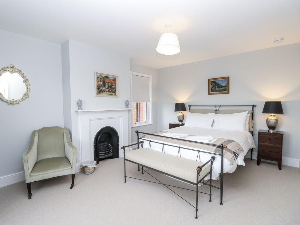 A bedroom with a bed, chair, and fireplace at Milston in Chale