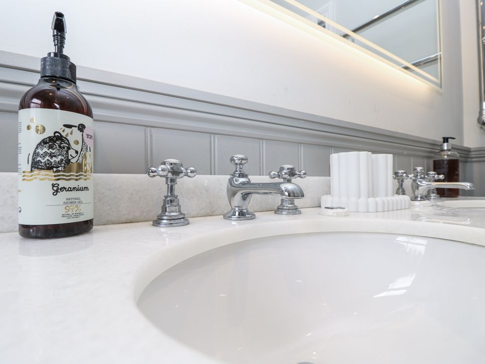 A bathroom countertop with sink and various toiletries at Milston in Chale