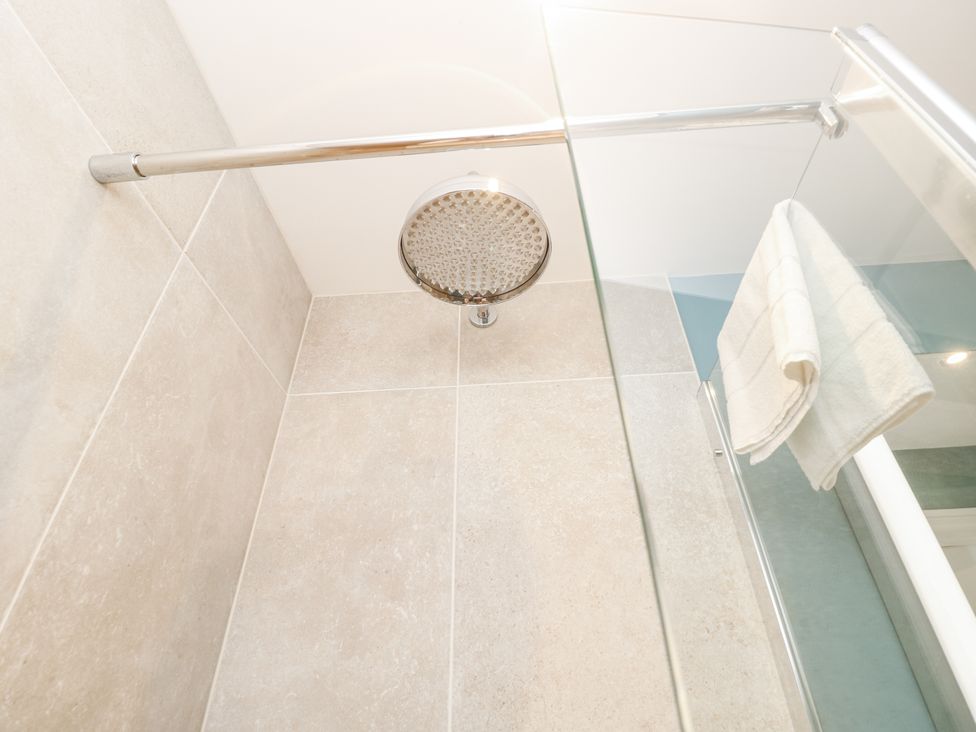 A bathroom with a showerhead and towel at Milston in Chale