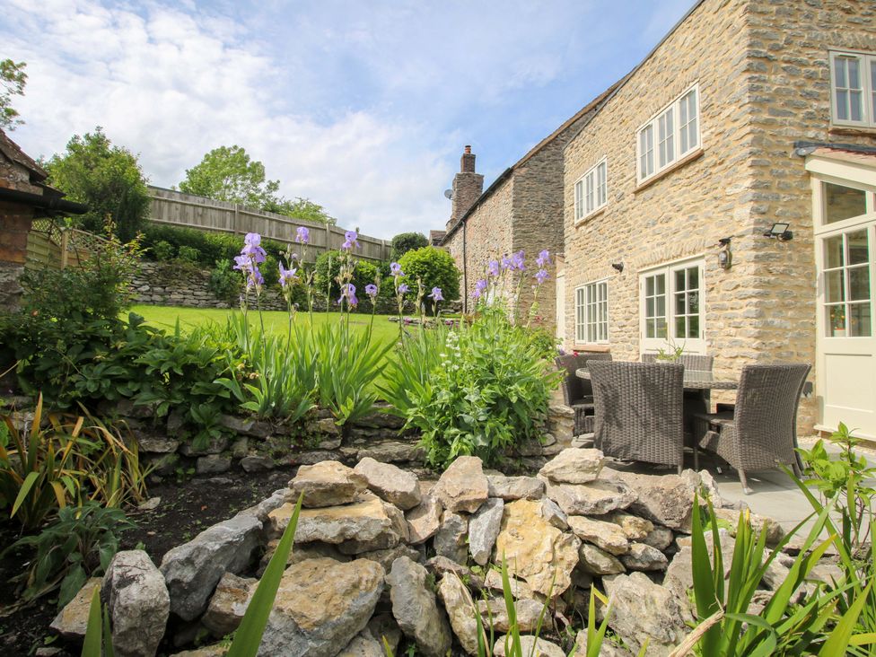 A garden with flowers and seating area at 5 Shrewsbury Road Much Wenlock