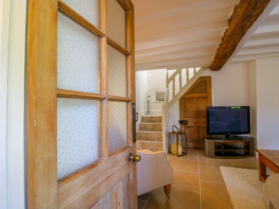 A living room with a television and stairs at 5 Shrewsbury Road Much Wenlock