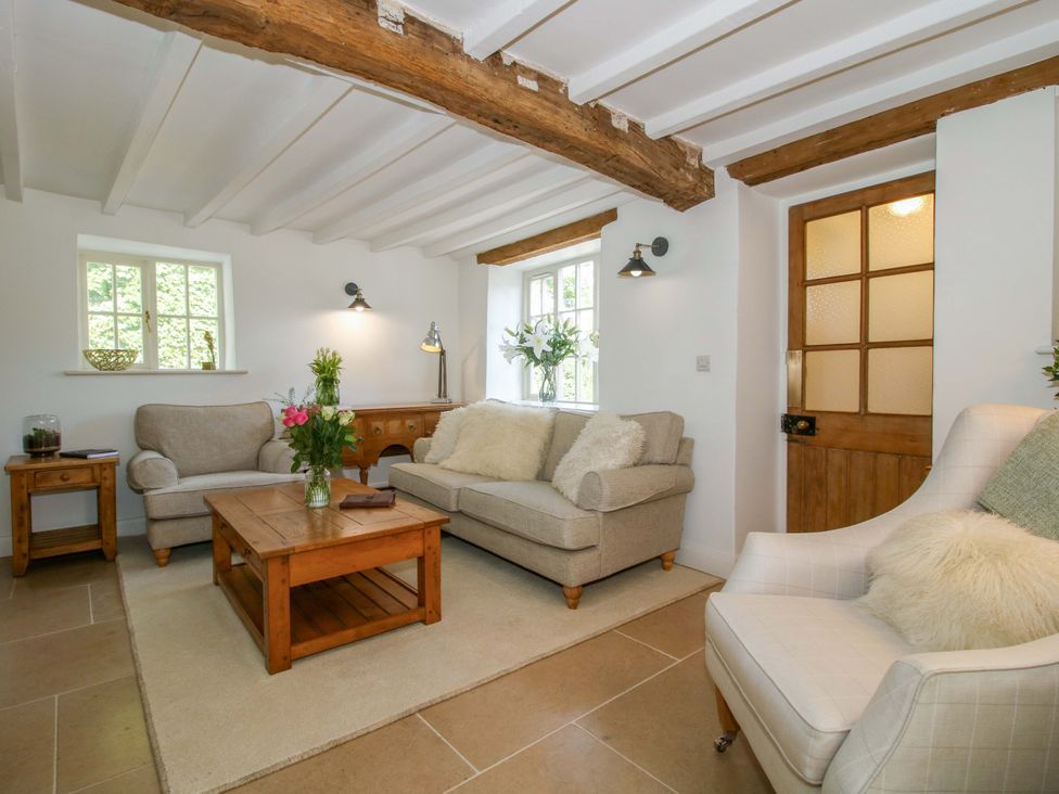 A living room with a sofa and armchair at 5 Shrewsbury Road in Much Wenlock